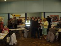 Residents mingling and taking advantage of the food.  One resident looks too engrossed in the newsletter to have noticed!