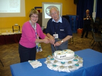 A close up of Ron and Lesley cutting the cake