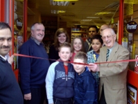 Ron cutting the ribbon, surrounded by children